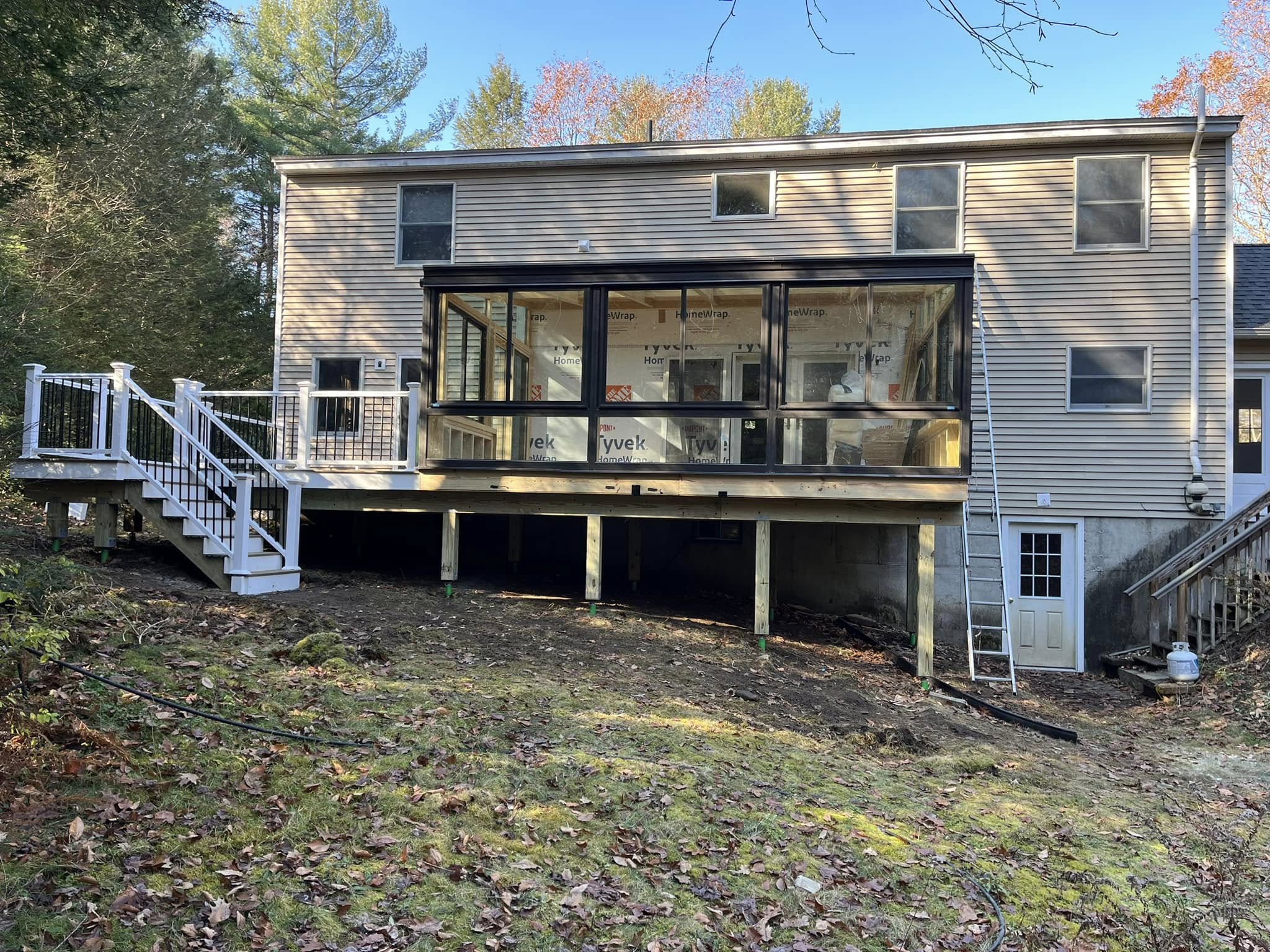 Deck or porch project by Handy Lou's — house with sunroom under construction