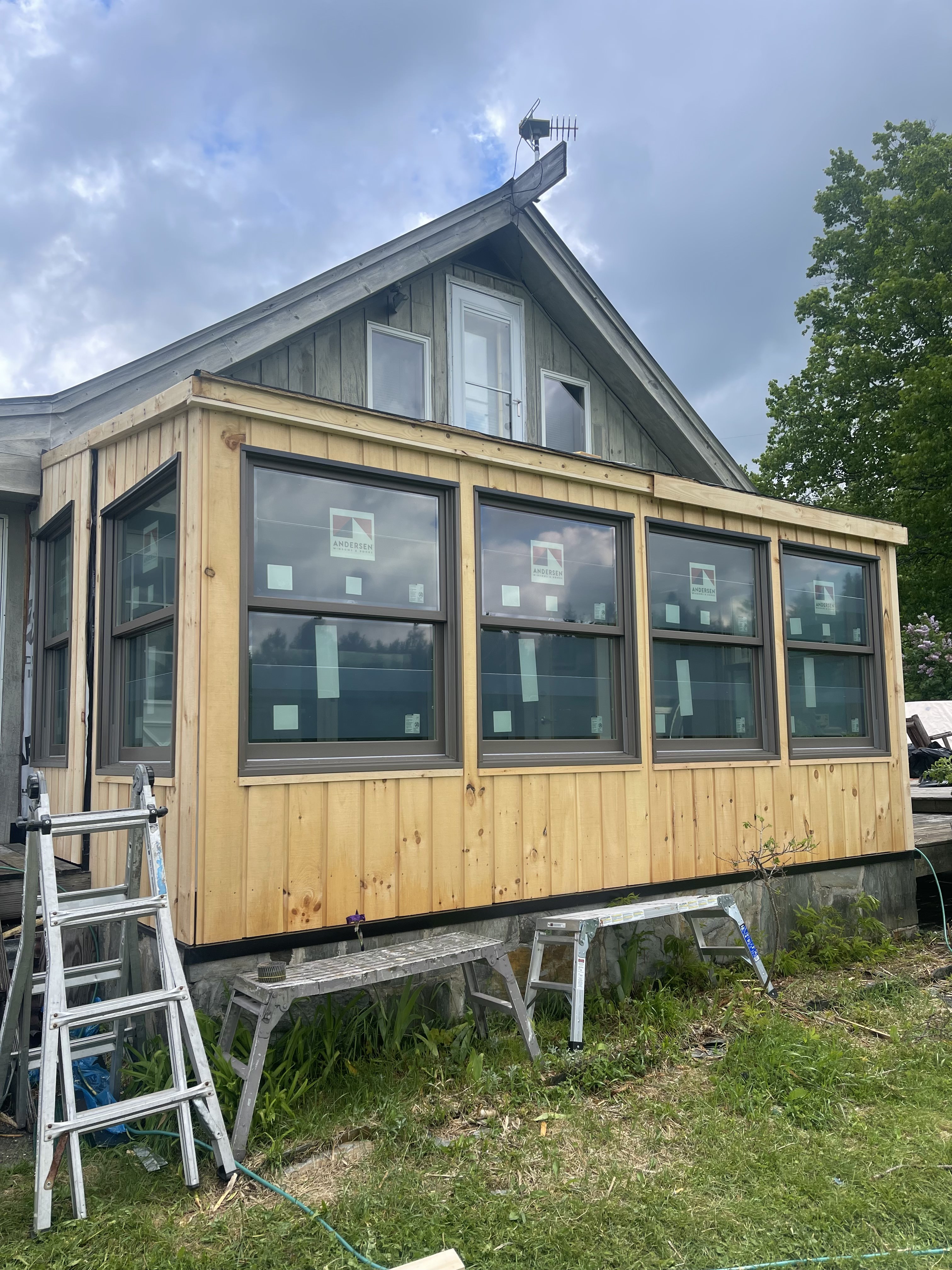 New cedar-sided addition with Andersen windows under construction