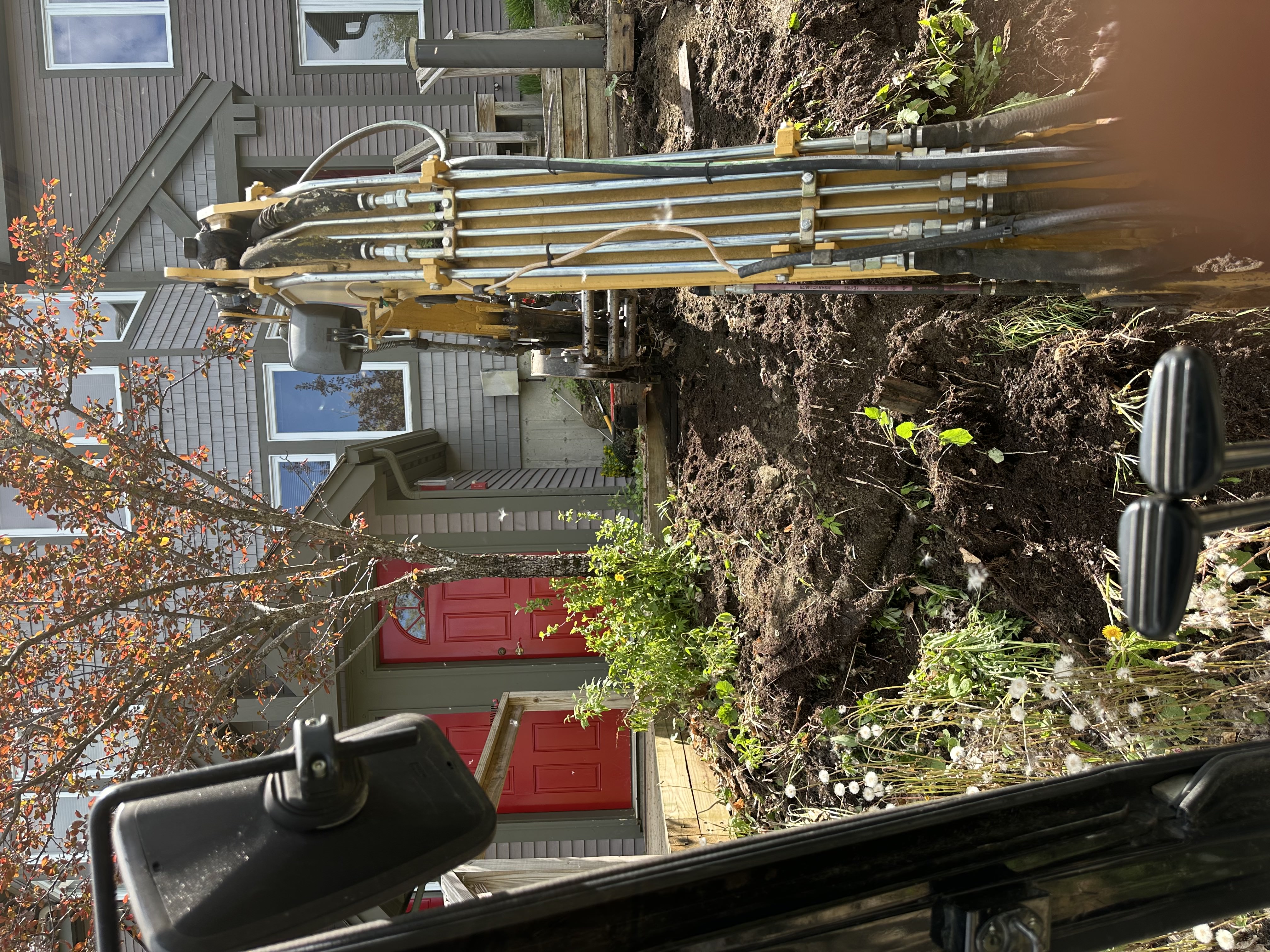 Excavation equipment working on residential property foundation
