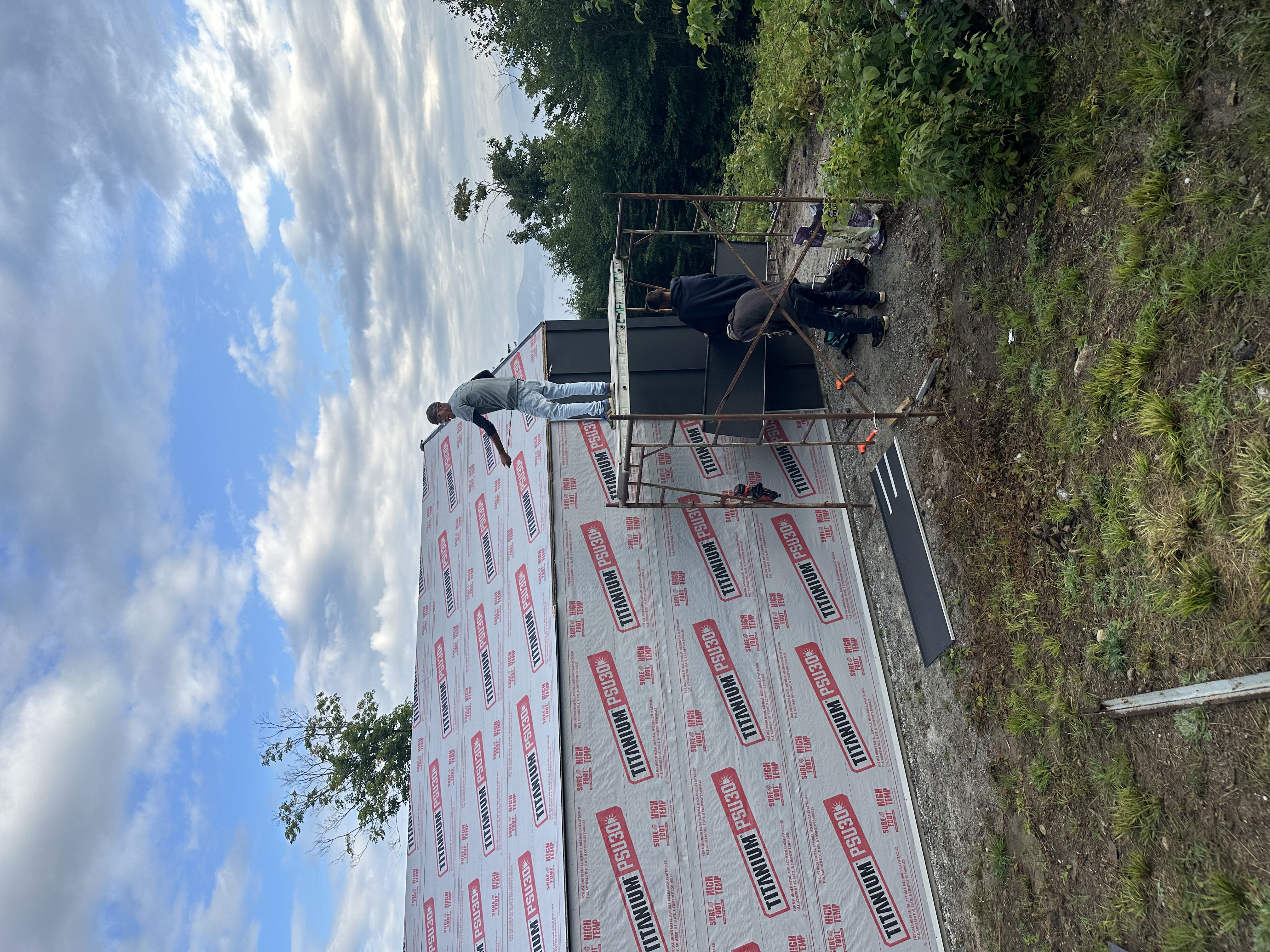 Roof underlayment installation with scaffolding on Vermont property