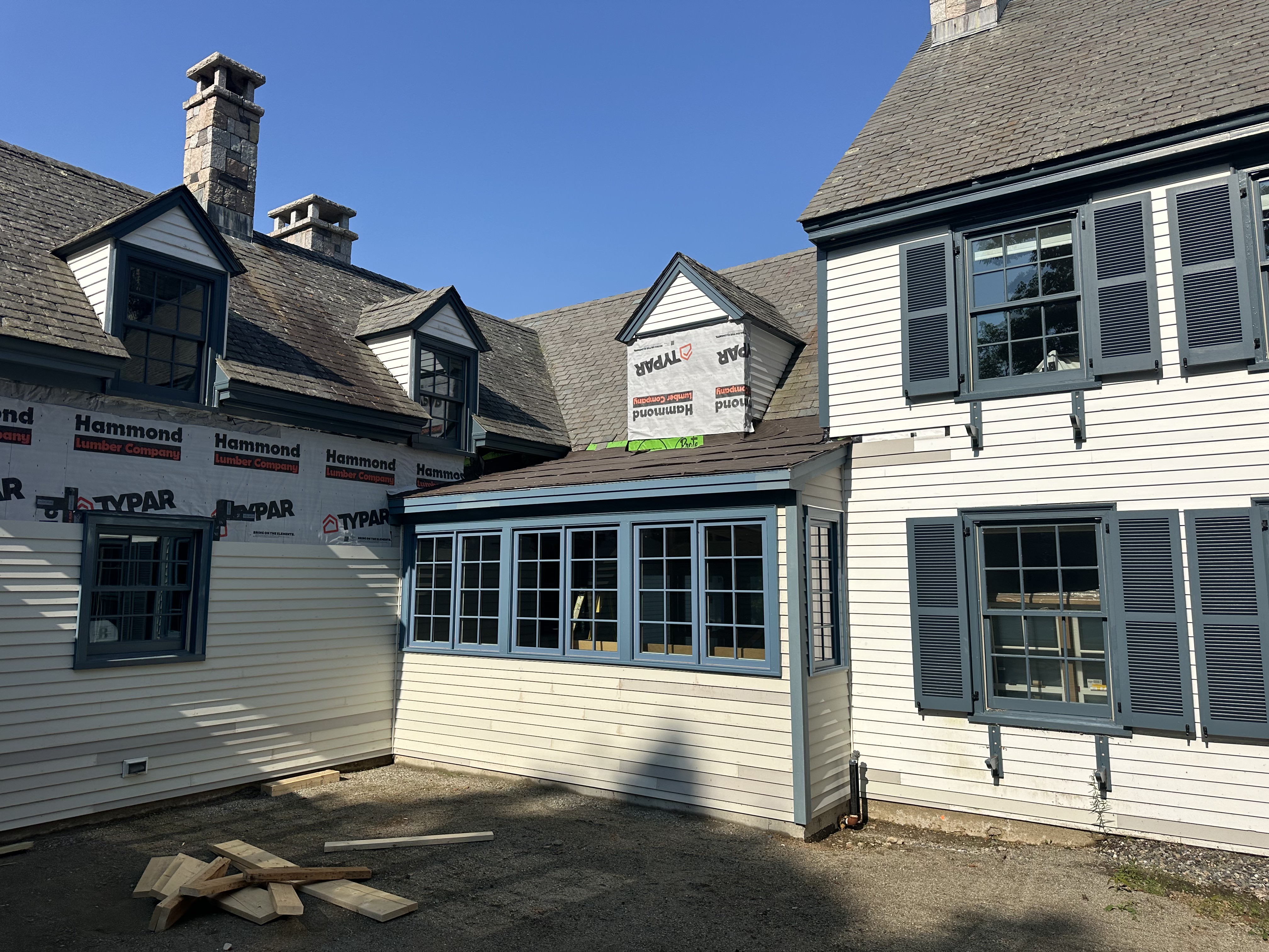 Historic home renovation with new slate roof and blue shuttered windows