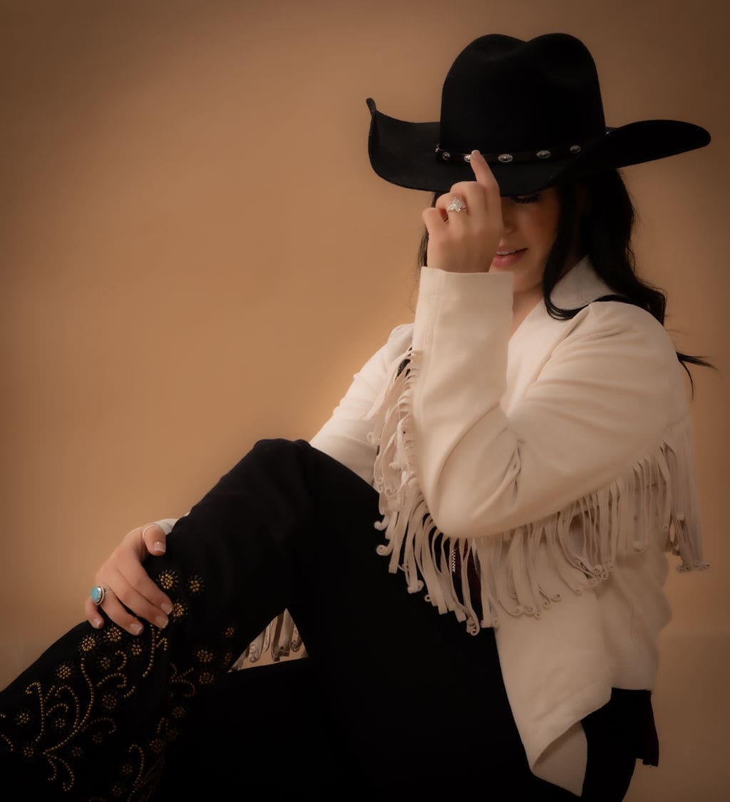 Cowgirl with hat over eyes close-up by Brooke Lazzarini