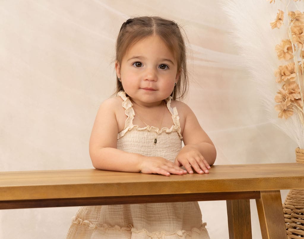 Toddler leaning on bench close-up portrait by Brooke Lazzarini