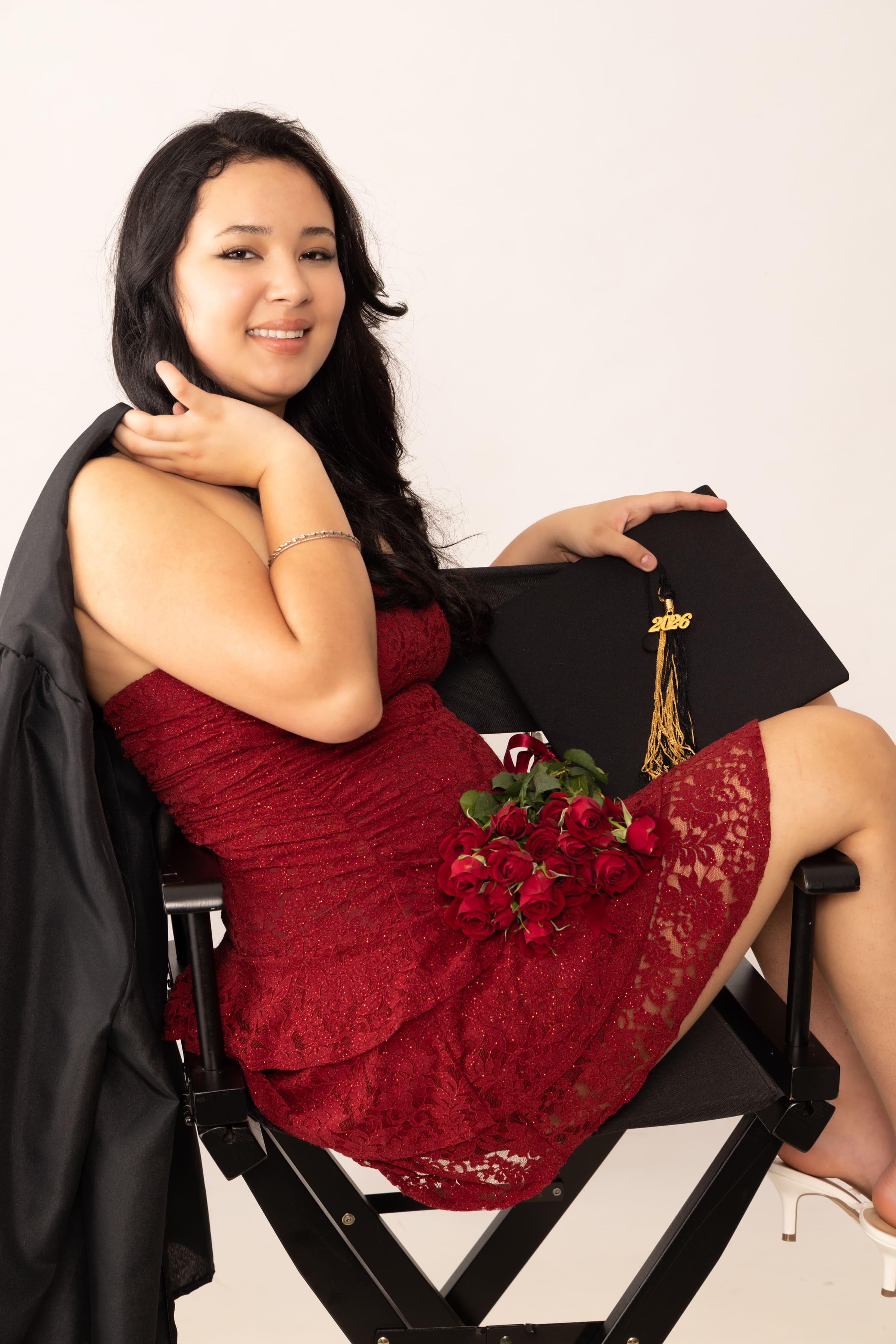 Senior in red lace dress with cap and gown by Brooke Lazzarini