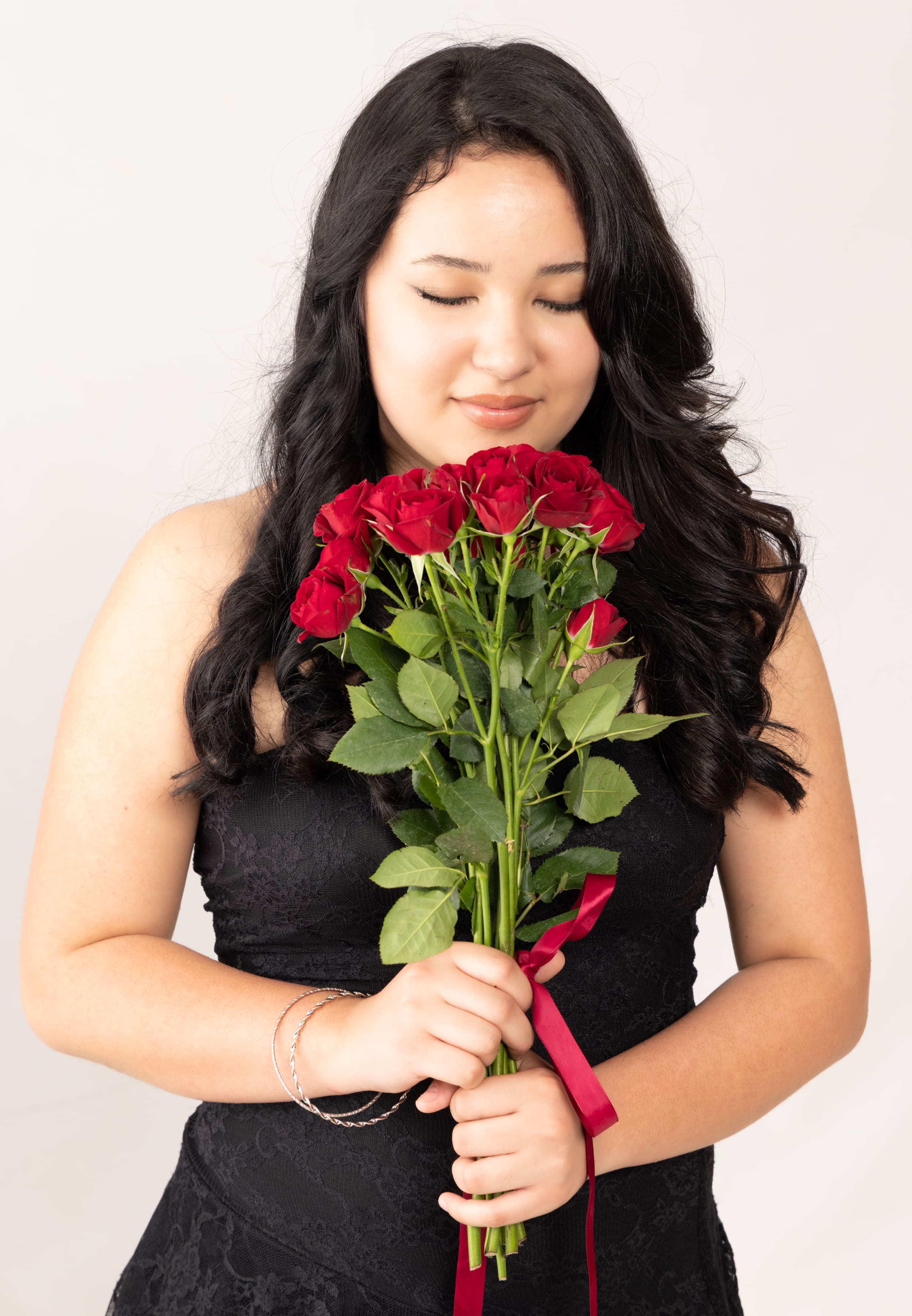 Senior in black dress with red roses bouquet portrait by Brooke Lazzarini