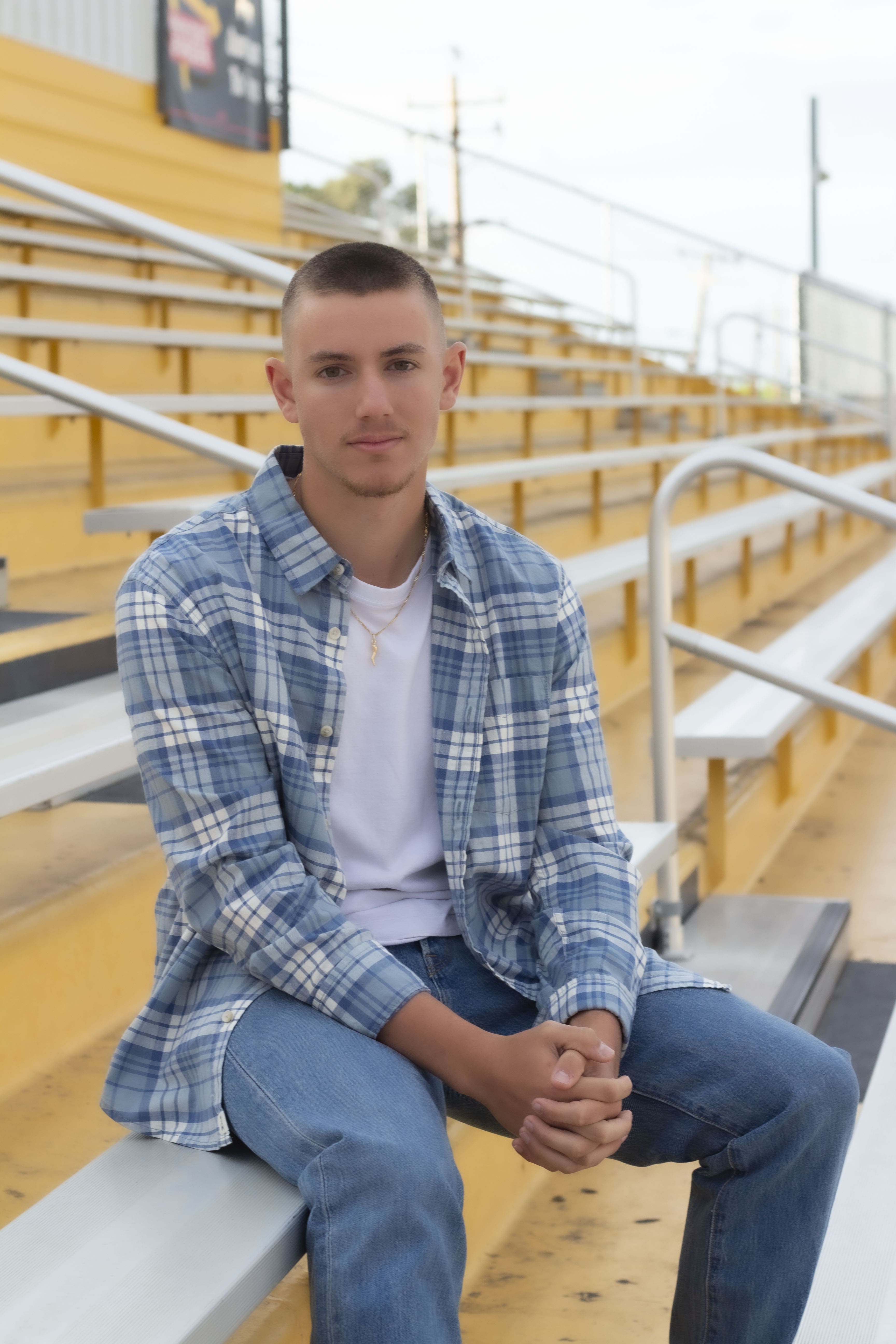 Senior portrait seated on bleachers by Brooke Lazzarini