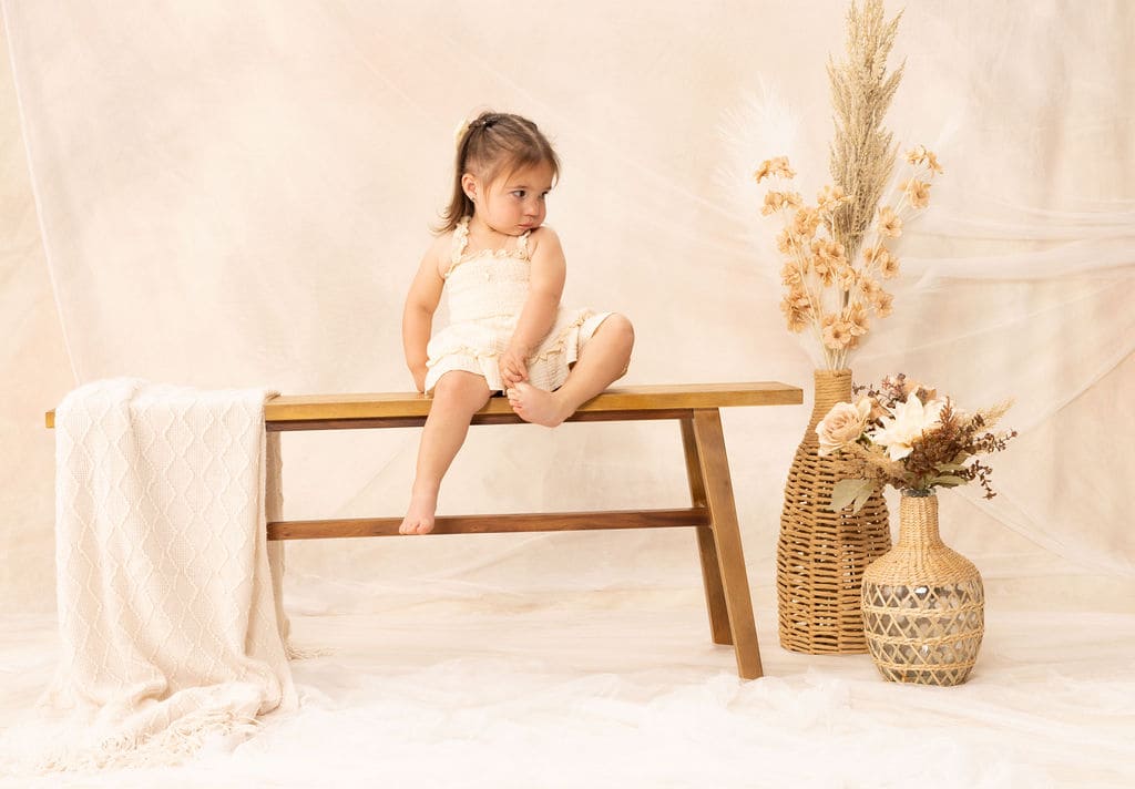 Toddler sitting on bench portrait by Brooke Lazzarini