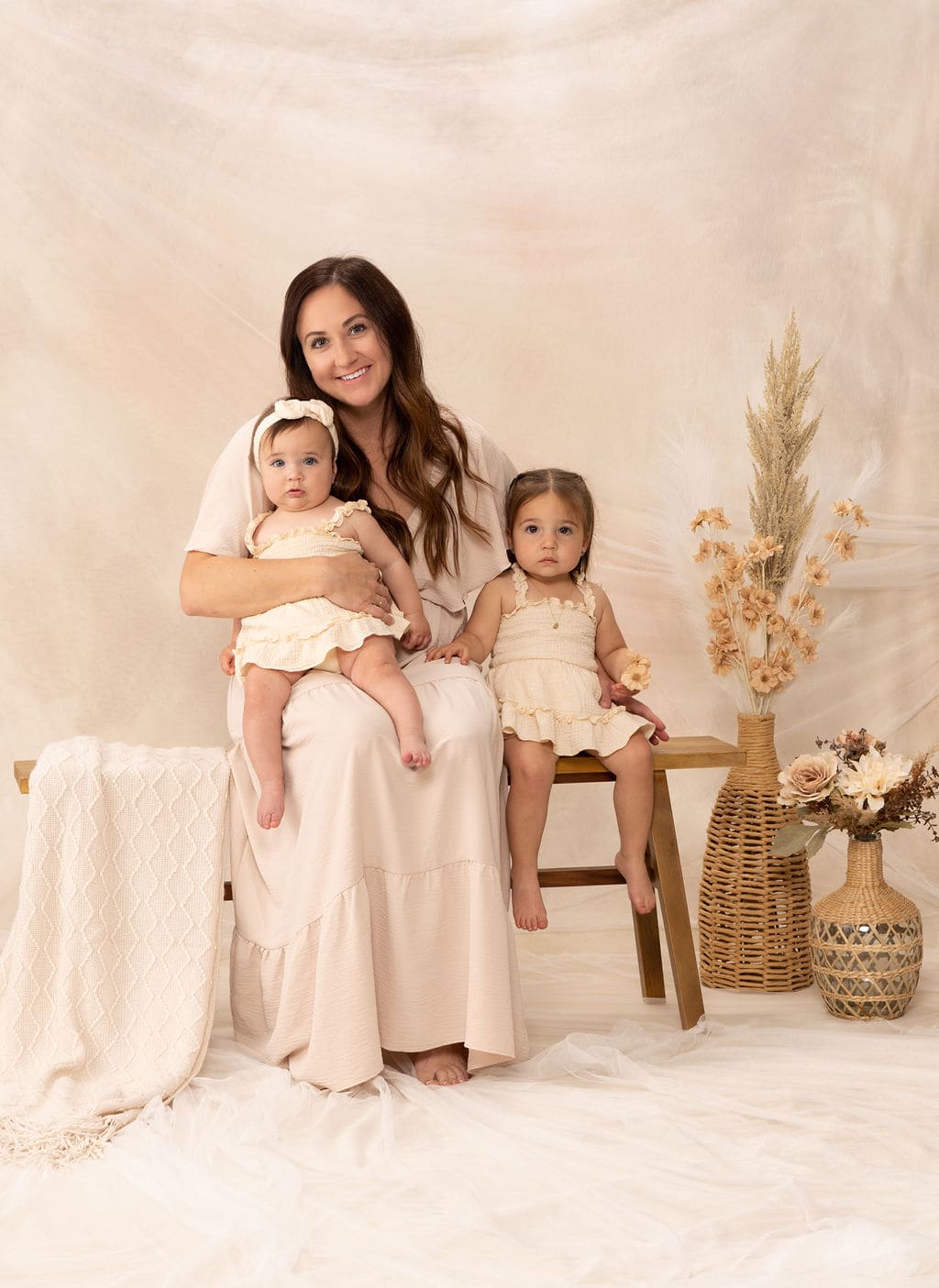 Mother and two girls on bench portrait by Brooke Lazzarini