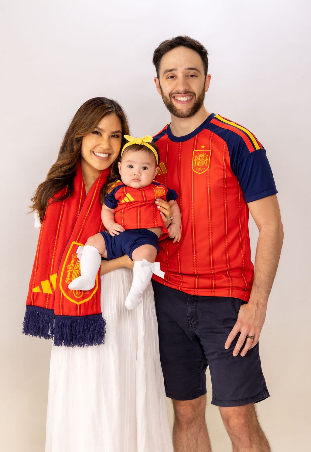 Family in Spain soccer jersey smiling portrait by Brooke Lazzarini