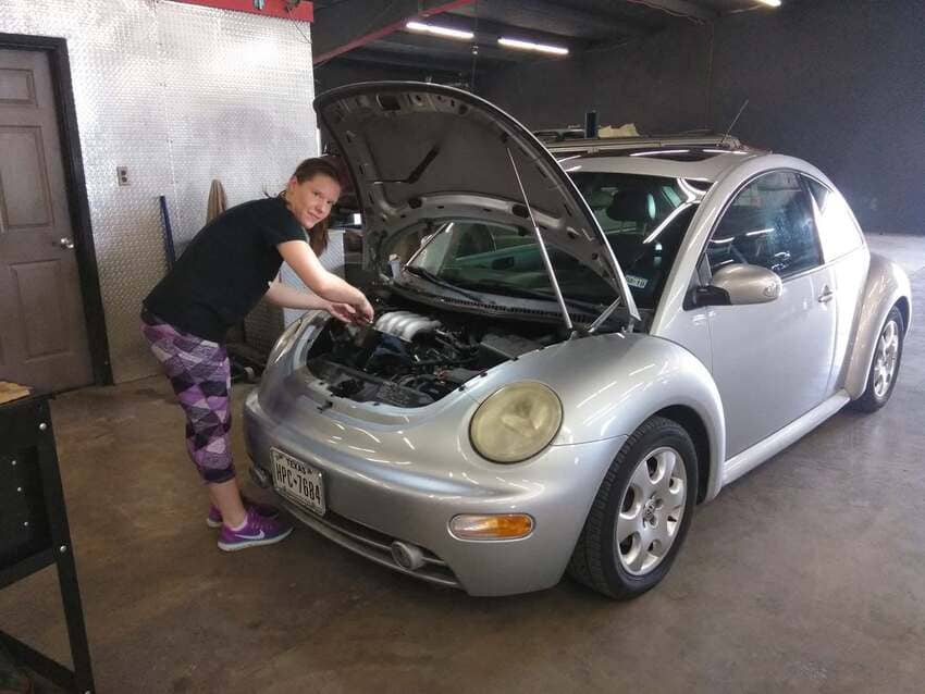 Technician performing engine diagnostics on silver vehicle in our service bay