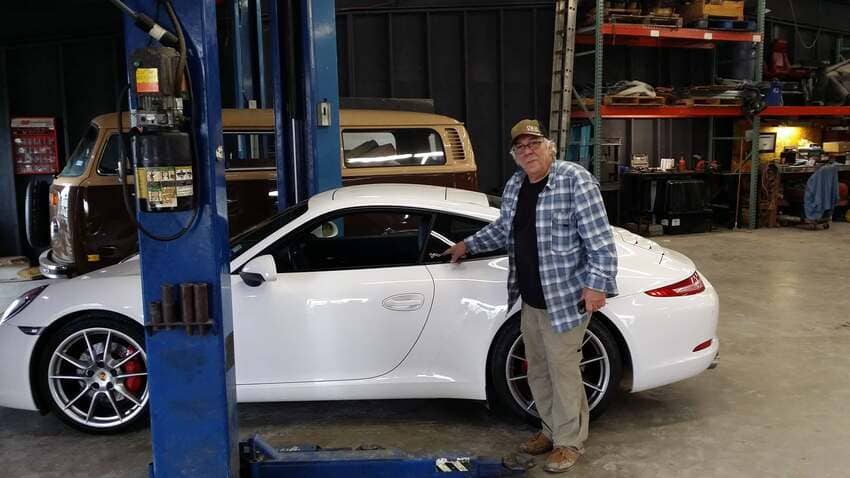White Porsche positioned on service lift in our clean diesel repair facility