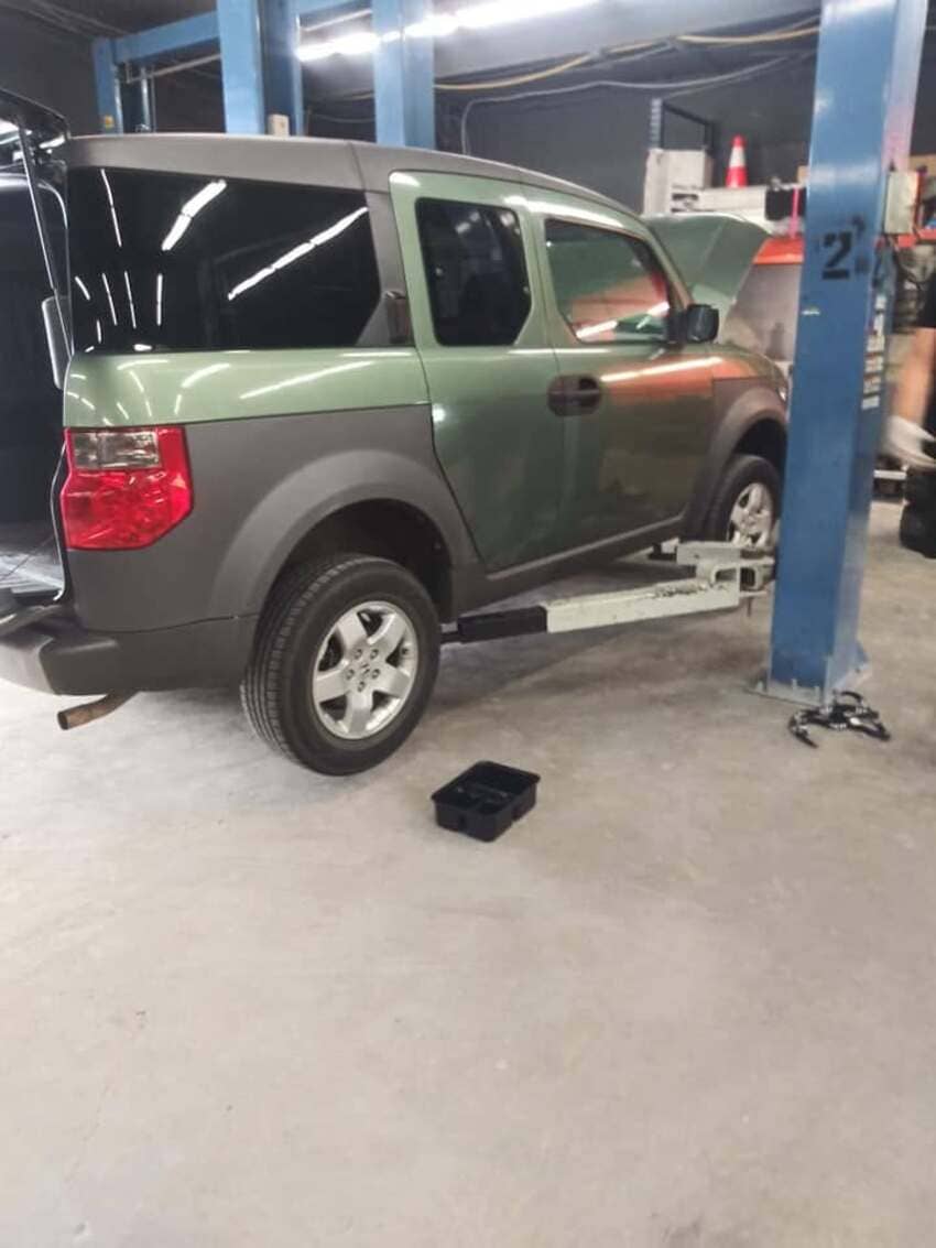 Green SUV positioned on service lift in our Austin diesel repair facility