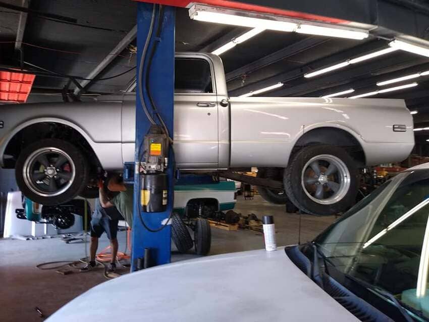 Classic silver pickup truck on lift in The Austin Diesel Specialists shop