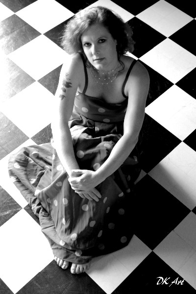 Morgan on a black and white checkered floor wearing playful polka-dot patterns — grounded, artistic, alive, the spiral path of becoming