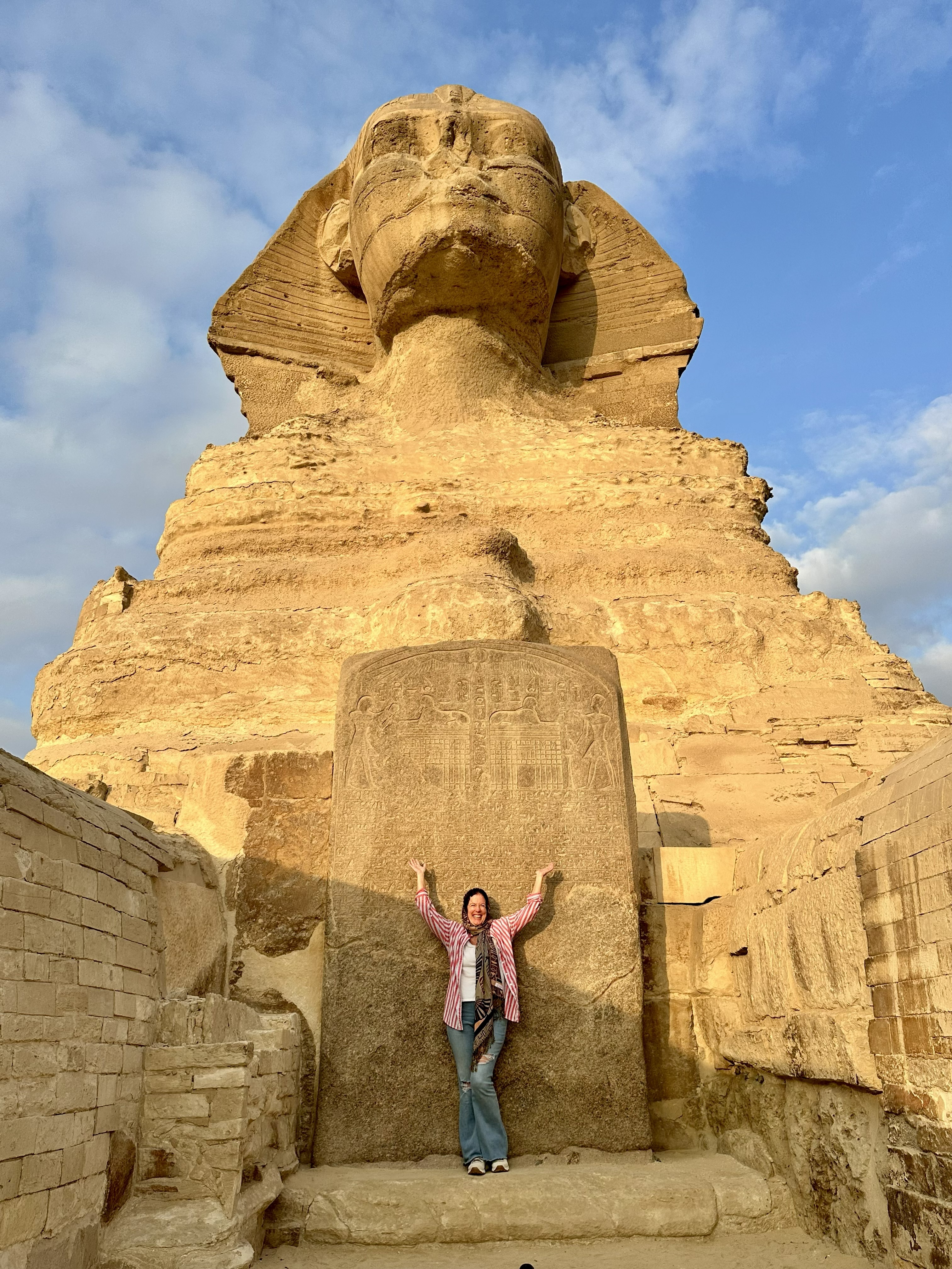 Morgan standing before the Great Sphinx of Giza with arms raised wide — Egypt pilgrimage, 2025