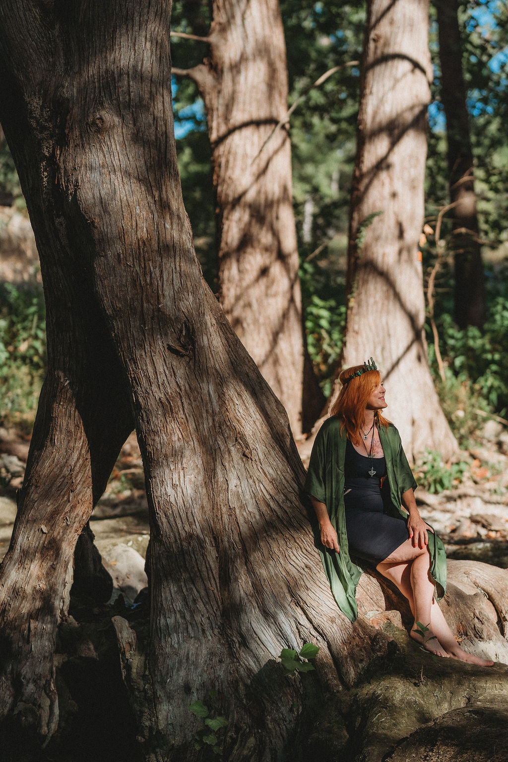 Morgan sitting with an ancient tree — rooted, present, and in sacred exchange with the earth