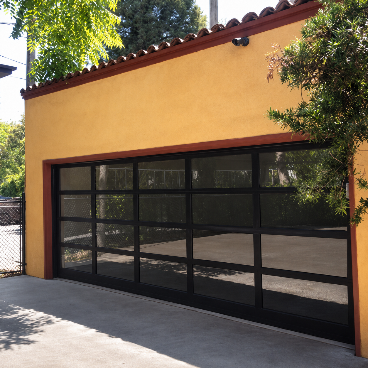 Custom black aluminum-and-glass sectional garage door on Spanish stucco home installed by JT Garage Doors in San Jose