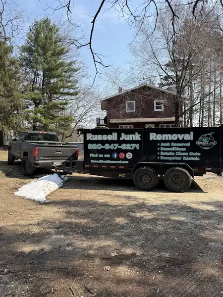 Russell Junk Removal truck and trailer parked at residential junk removal job site