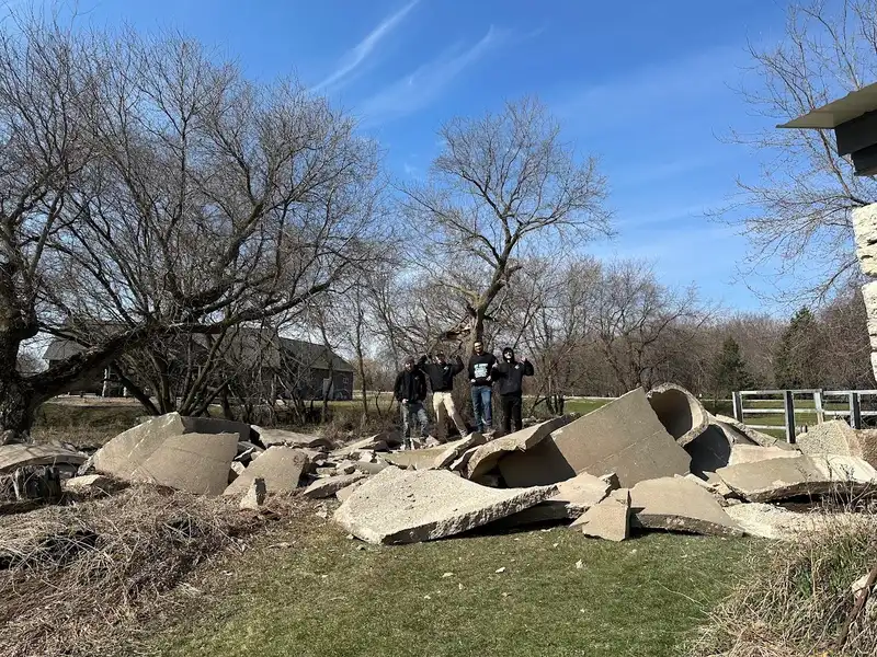 Russell Junk Removal team standing by loaded trailer after a cleanout job