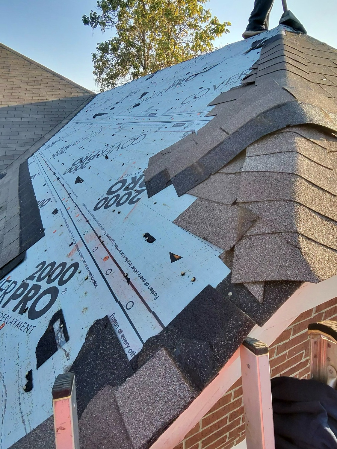 Roofing Glory crew performing a roof tear-off with fresh underlayment in North Texas