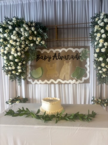 Baby shower dessert table with lush white floral arches and personalized banner