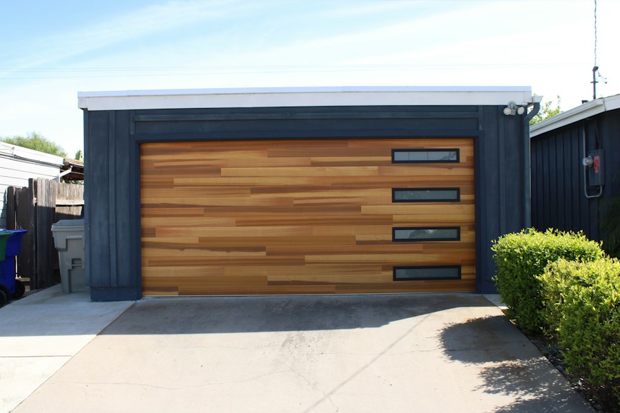 Wood-finish residential garage door with vertical windows