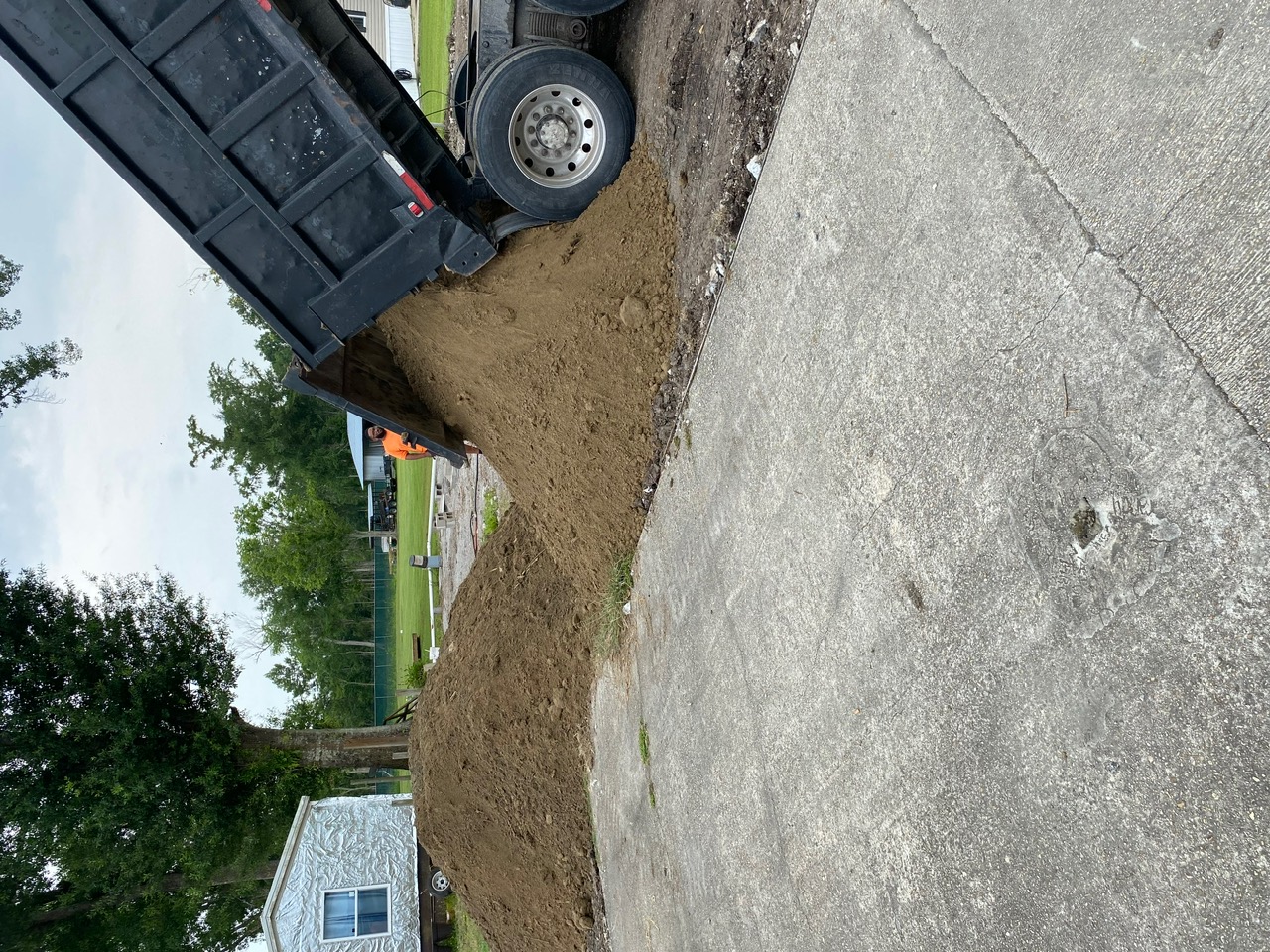 Dump truck delivering fill dirt for land grading and leveling