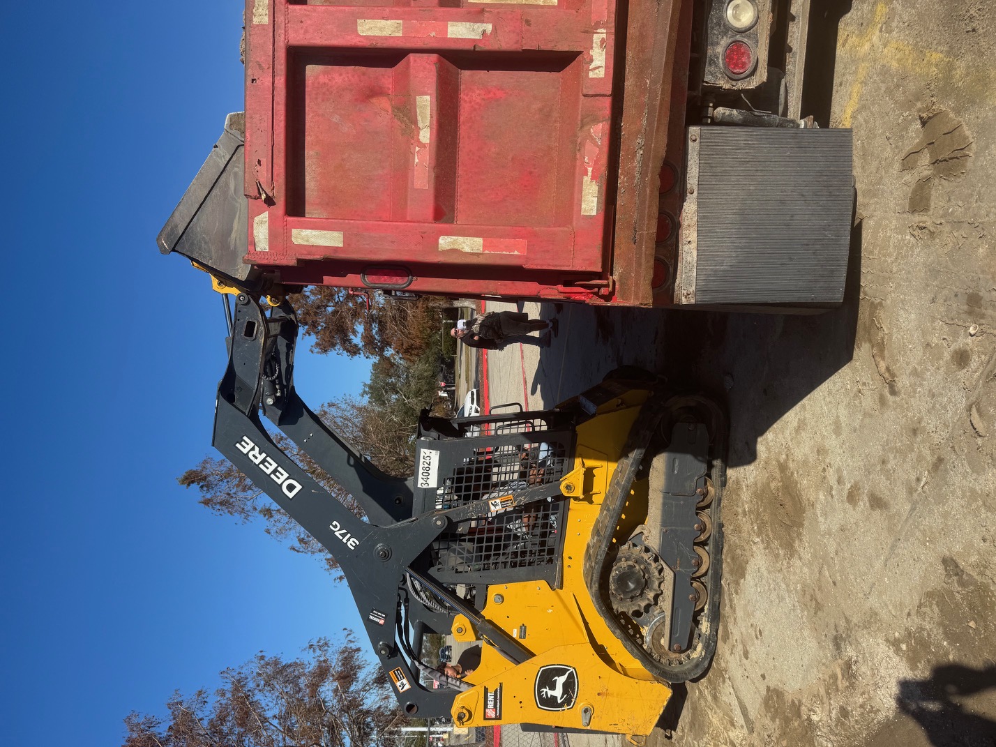 28 Blue Construction heavy equipment — dump truck and skid steer on job site