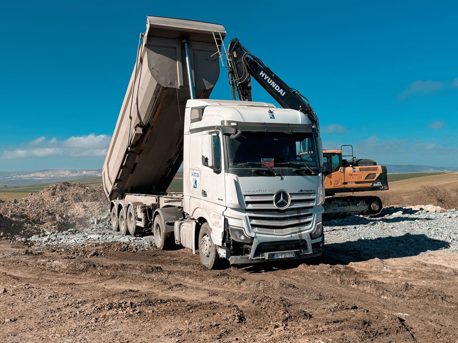 Dump truck and excavator working on a construction site — dump truck financing for contractors