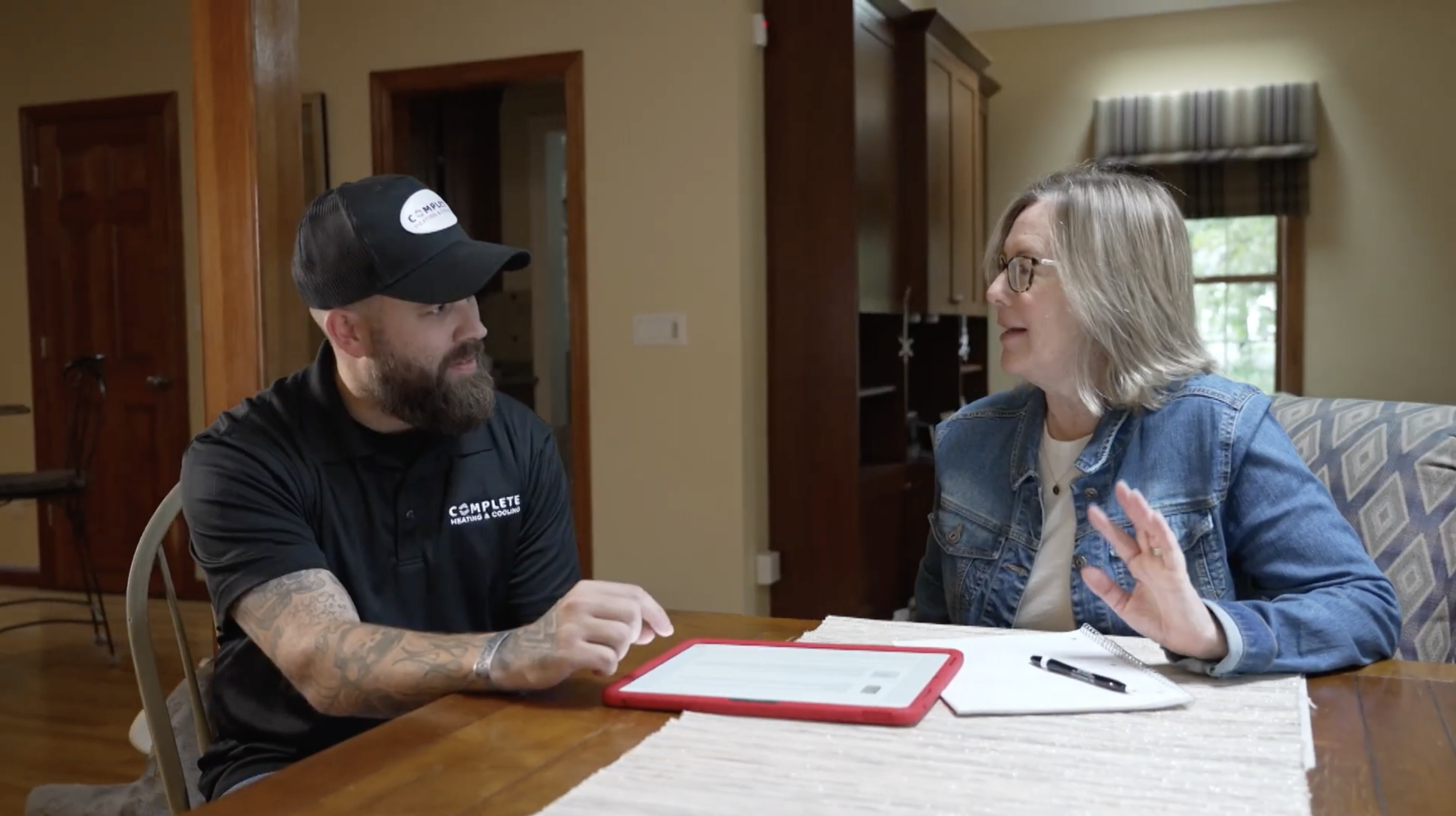 TF Complete technician consulting with a homeowner at their kitchen table