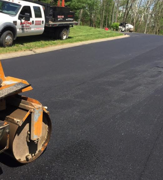 Freshly paved black asphalt residential driveway after installation