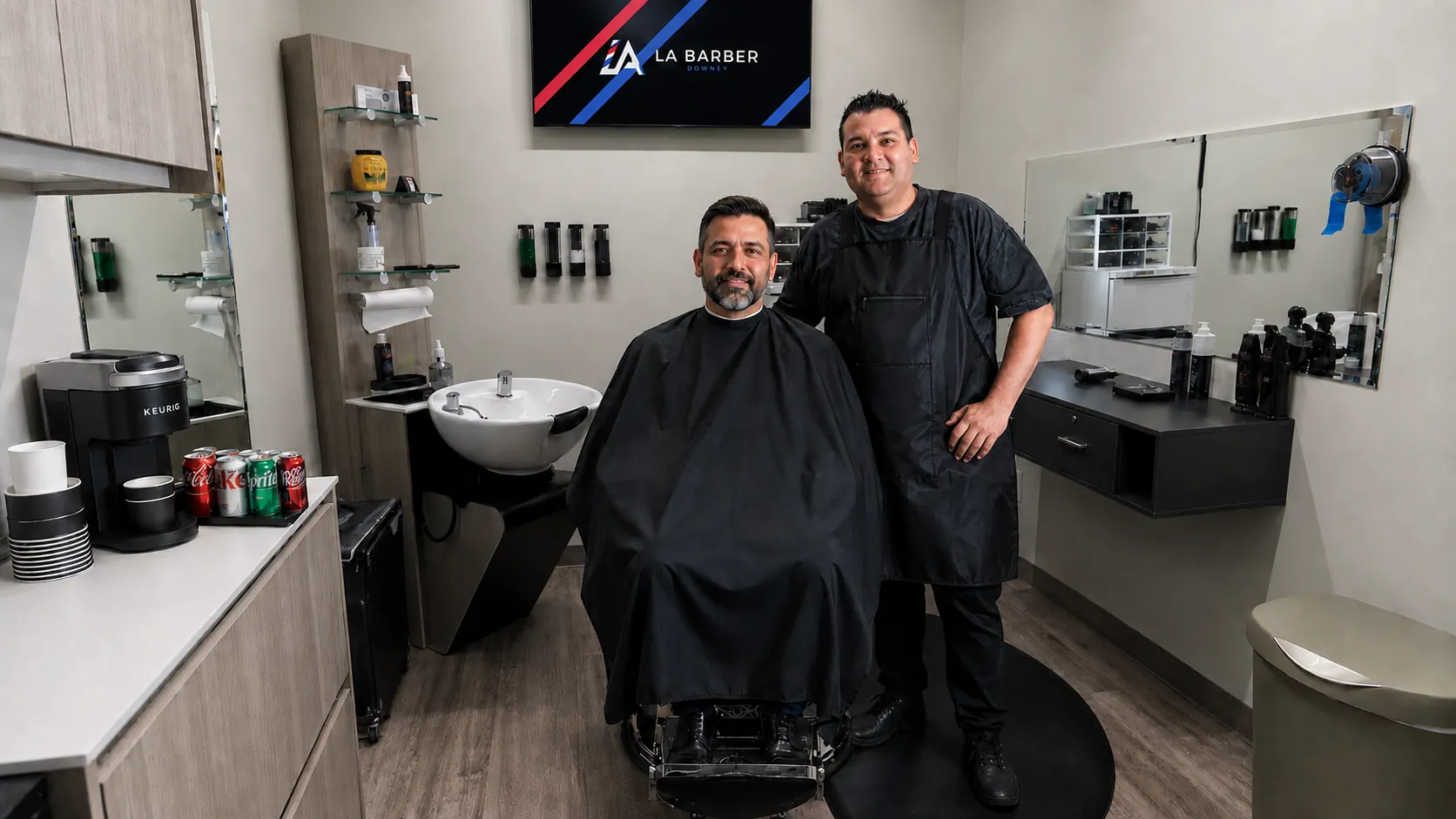 Interior of LA Barber Downey private suite at Sola Salons Stonewood Center, showing Lazaro with a client in the chair