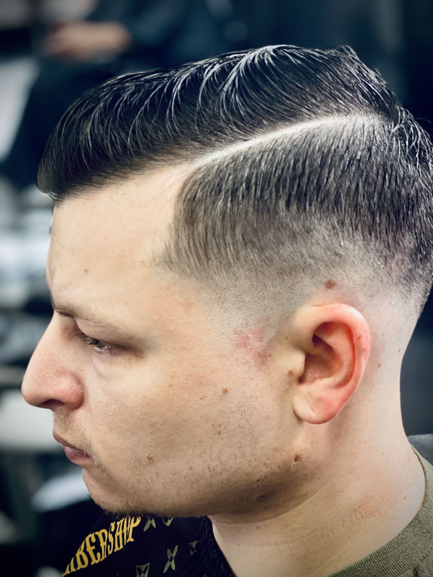 Hard part razor line with a textured comb-over and precision fade on the sides