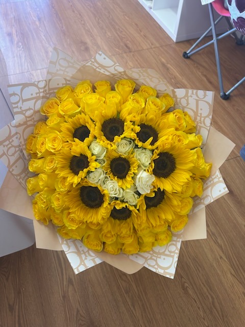 Grand luxury sunflower, yellow rose, and white rose round bouquet arranged with designer patterned paper wrap by FridAndre Florals