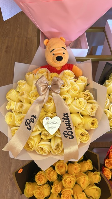 Winnie the Pooh plush bouquet with 36 vibrant yellow Ecuadorian roses, gold satin ribbon with 'Por Bonita' script, and crystal heart accent by FridAndre Florals