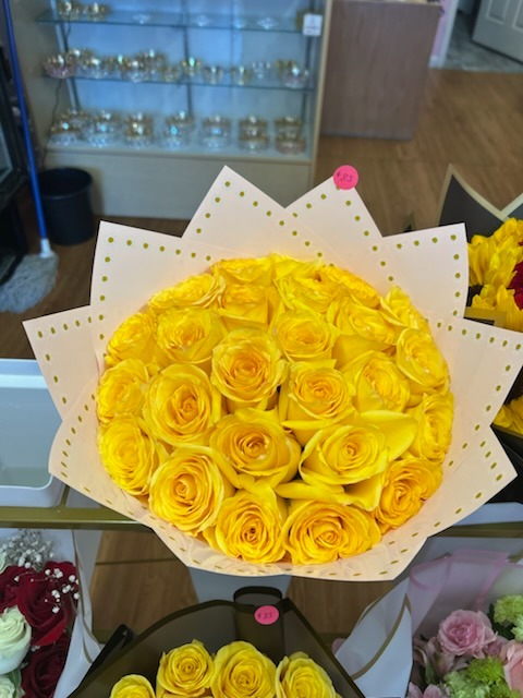 Vibrant yellow Ecuadorian rose round bouquet beautifully arranged in elegant white and gold polka dot star-point wrap by FridAndre Florals