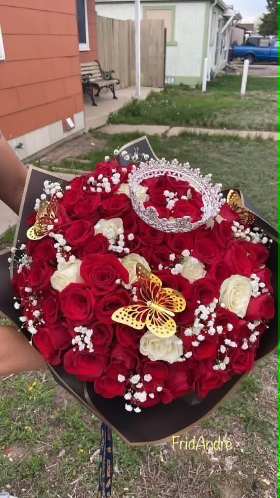 Stunning heart-shaped 100-rose deep red and cream white Ecuadorian rose bouquet with sparkling crystal crown tiara, golden laser-cut butterfly decorations, delicate white baby's breath border, sleek black geometric paper wrap - luxury romantic arrangement by FridAndre Florals