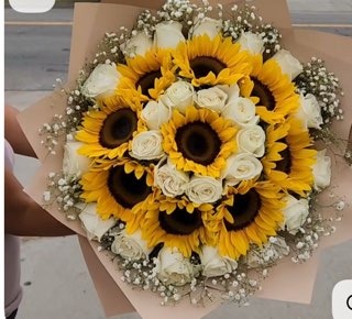 Fresh round bouquet of bright yellow sunflowers and pure white Ecuadorian roses accented with baby's breath in warm kraft paper wrap by FridAndre Florals