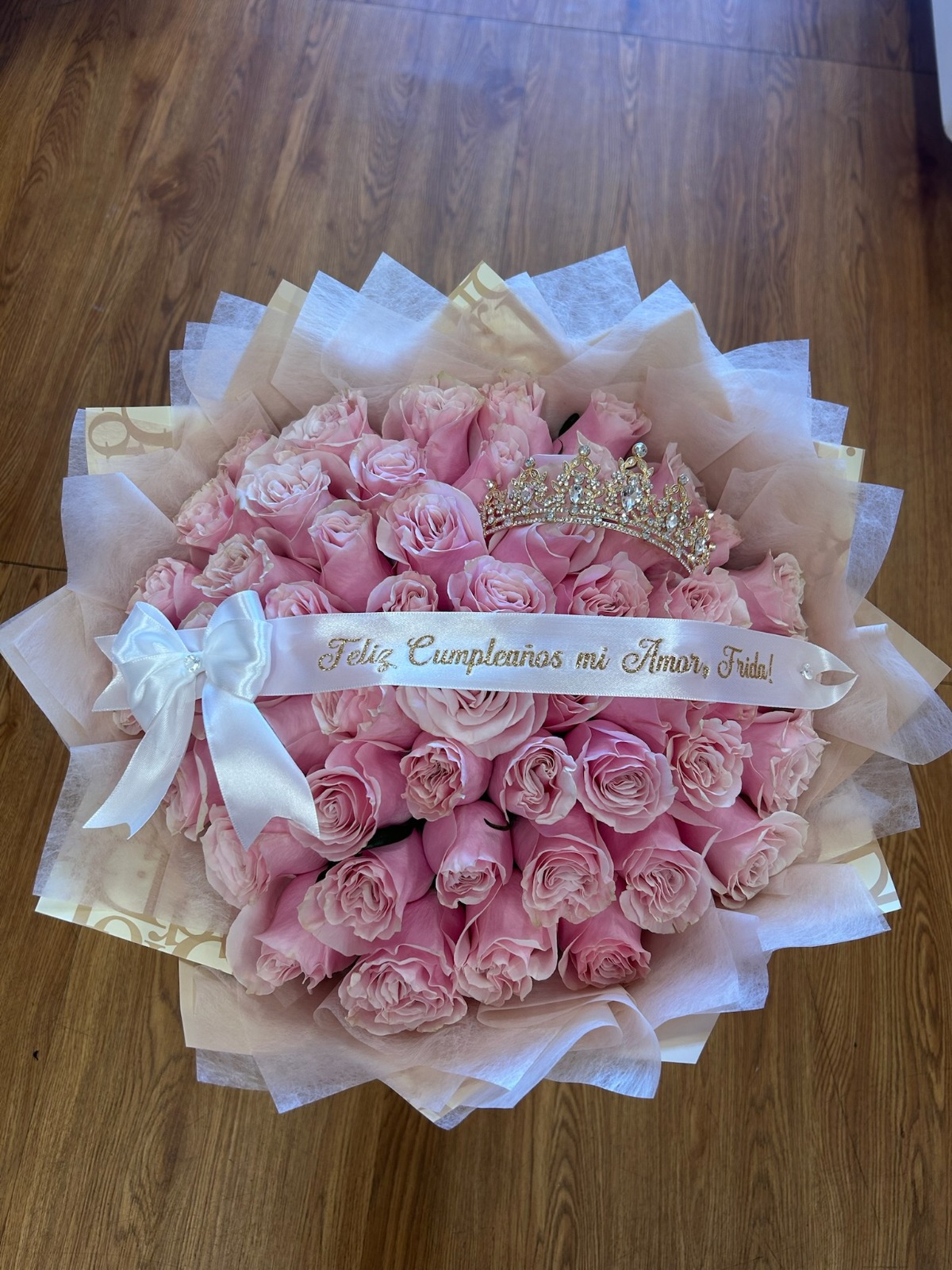 Stunning 'Feliz Cumpleaños mi Amor, Frida!' 50-rose soft pink Ecuadorian rose bouquet with sparkling crystal crown tiara, elegant white and gold geometric paper wrap with white satin ribbon bow - luxury birthday love declaration arrangement by FridAndre Florals