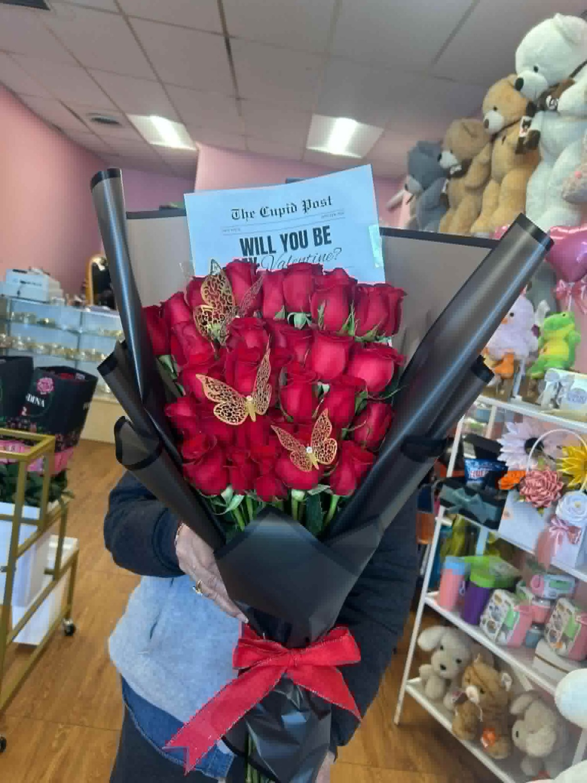 Romantic 'Will You Be My Valentine?' 25-rose red Ecuadorian rose bouquet with golden laser-cut butterfly decorations, 'The Cupid Post' Valentine proposal card, sleek black geometric paper wrap, and vibrant red satin ribbon bow