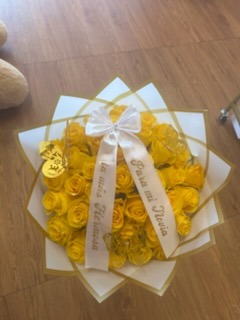 Vibrant yellow Ecuadorian rose bouquet adorned with golden laser-cut butterflies, sparkling crystal crown tiara, and crisp white geometric paper wrap by FridAndre Florals
