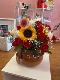 Sunflower and mixed roses in ceramic vase