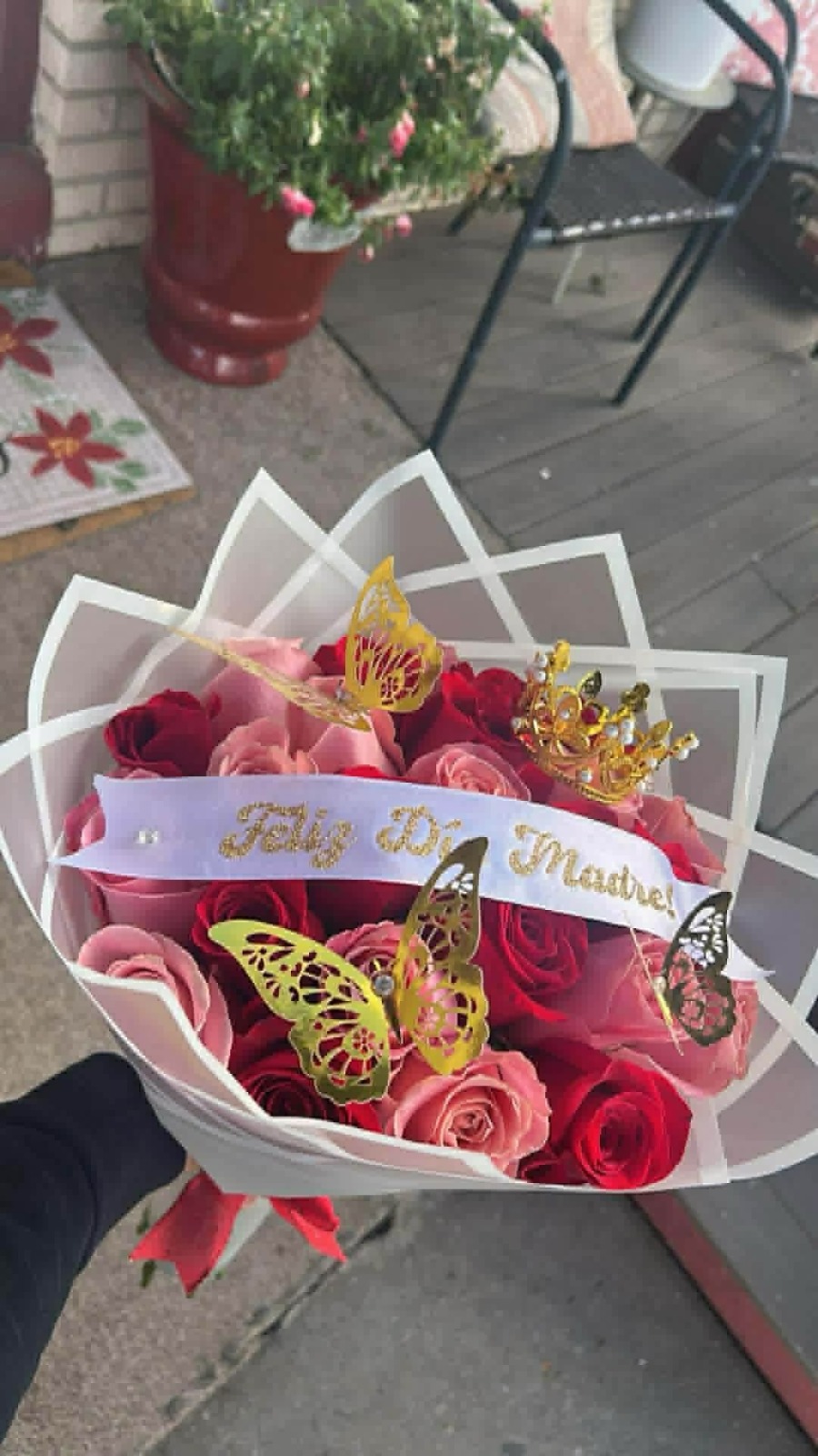 Beautiful 'Feliz Día Maestro!' red and pink Ecuadorian rose bouquet with golden jeweled crown tiara, golden laser-cut butterfly decorations, white geometric paper wrap, and 'Feliz Día Maestro!' gold-glitter lettered satin ribbon bow - teacher appreciation arrangement