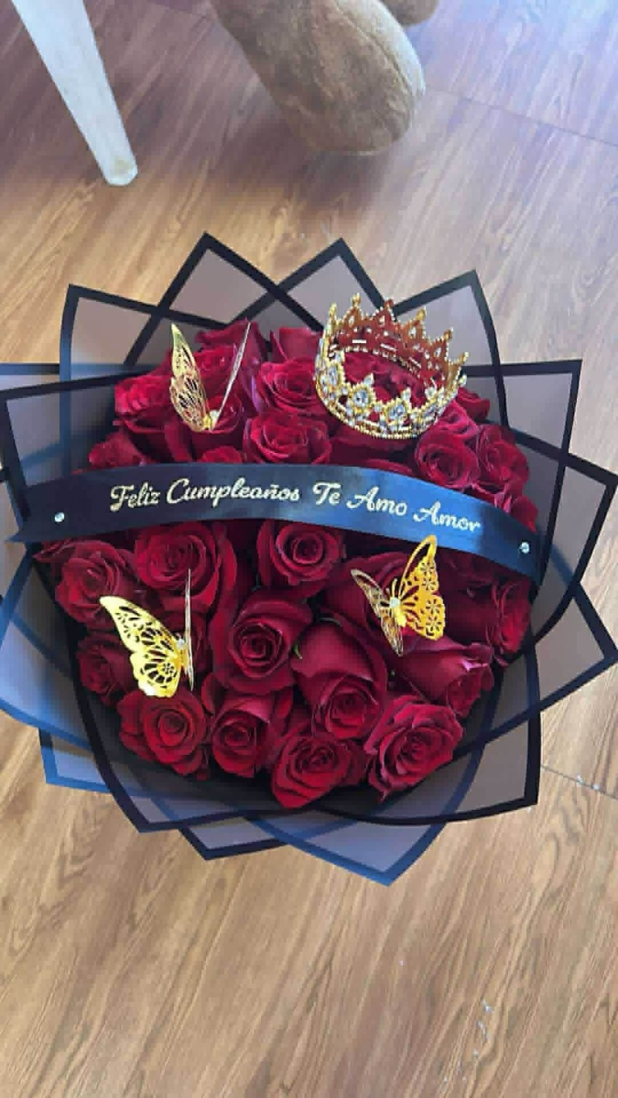 Romantic 'Feliz Cumpleaños Te Amo Amor' 36-rose deep red Ecuadorian rose bouquet with sparkling crystal crown tiara, golden laser-cut butterfly decorations, 'Feliz Cumpleaños Te Amo Amor' gold-glitter lettered satin ribbon bow, and sleek black geometric paper wrap - birthday love declaration arrangement