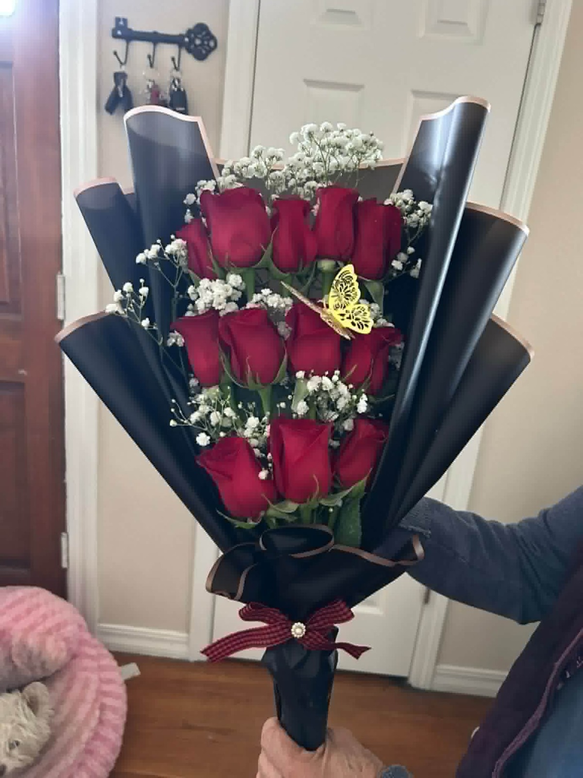 Elegant 12-rose red Ecuadorian rose bouquet with white baby's breath filler, golden laser-cut butterfly decoration, sleek black geometric paper wrap, and red plaid satin ribbon bow - luxury FridAndre compact arrangement