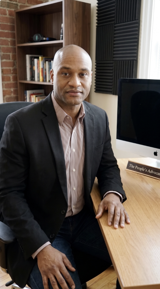 Akeiff Staples, founder of The People's Advocate, seated at his desk.