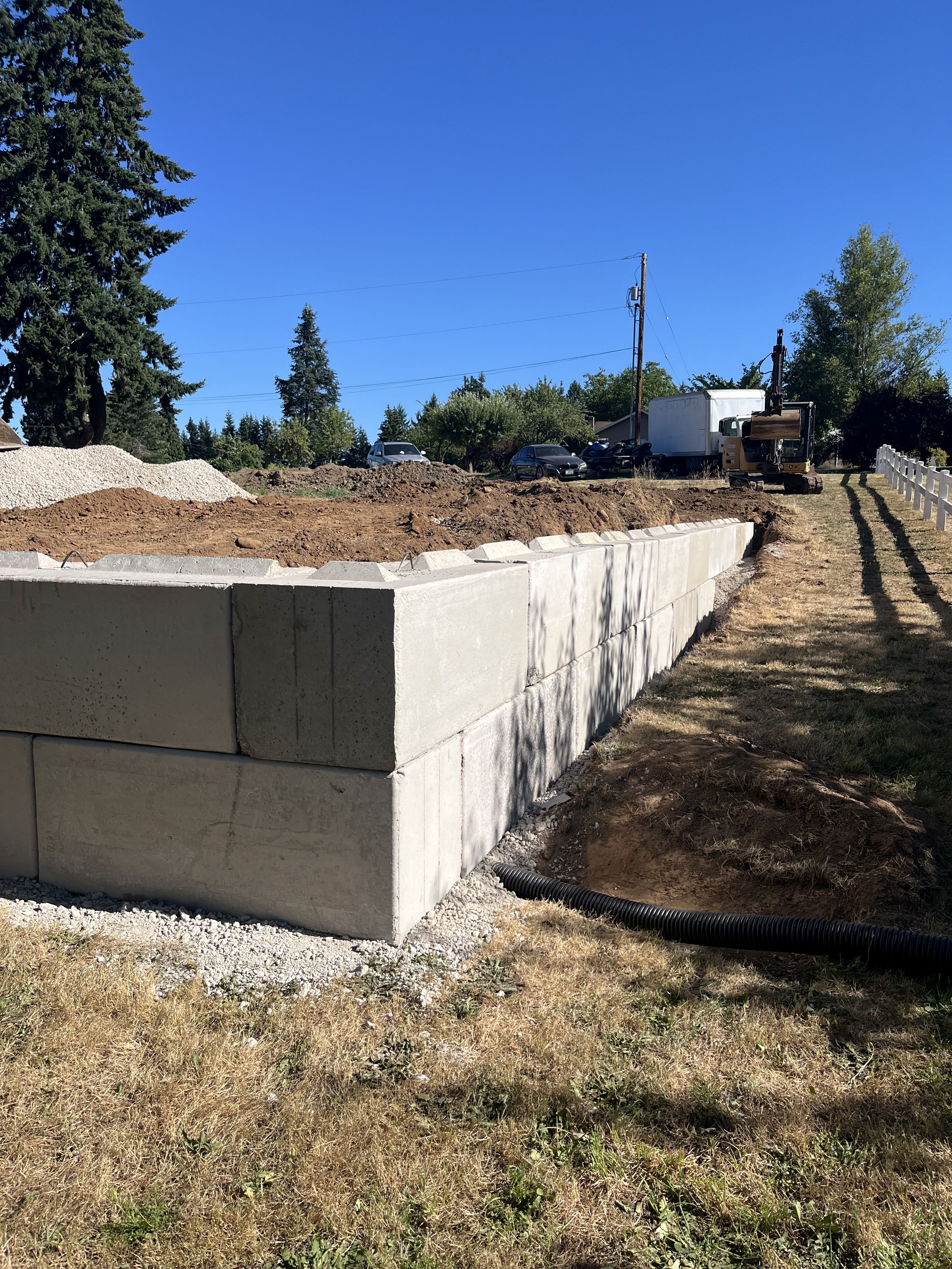 Excavation — Retaining wall corner build & sub-drainage pipe installation — representative project image