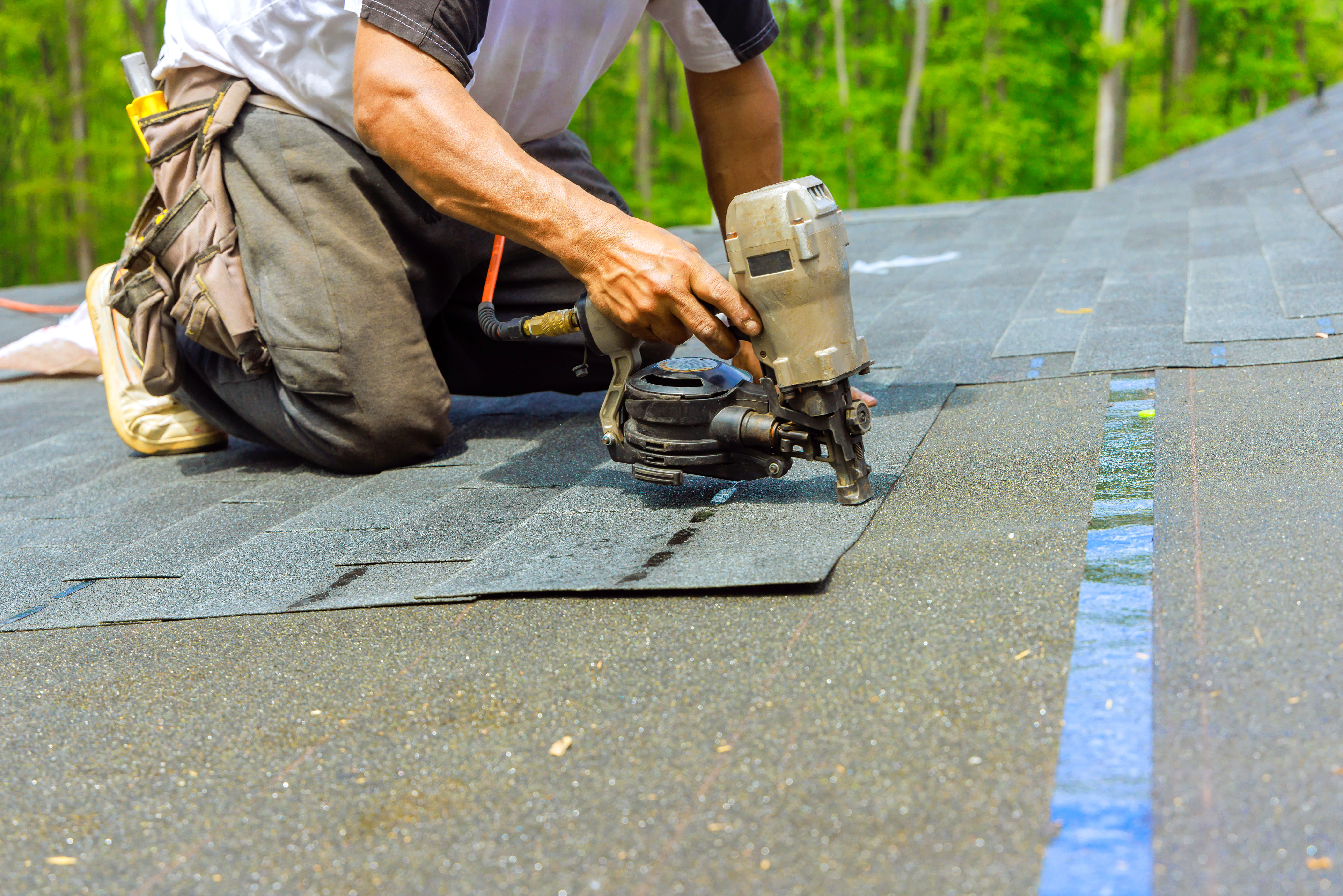 Two roofers working together on an emergency roof repair