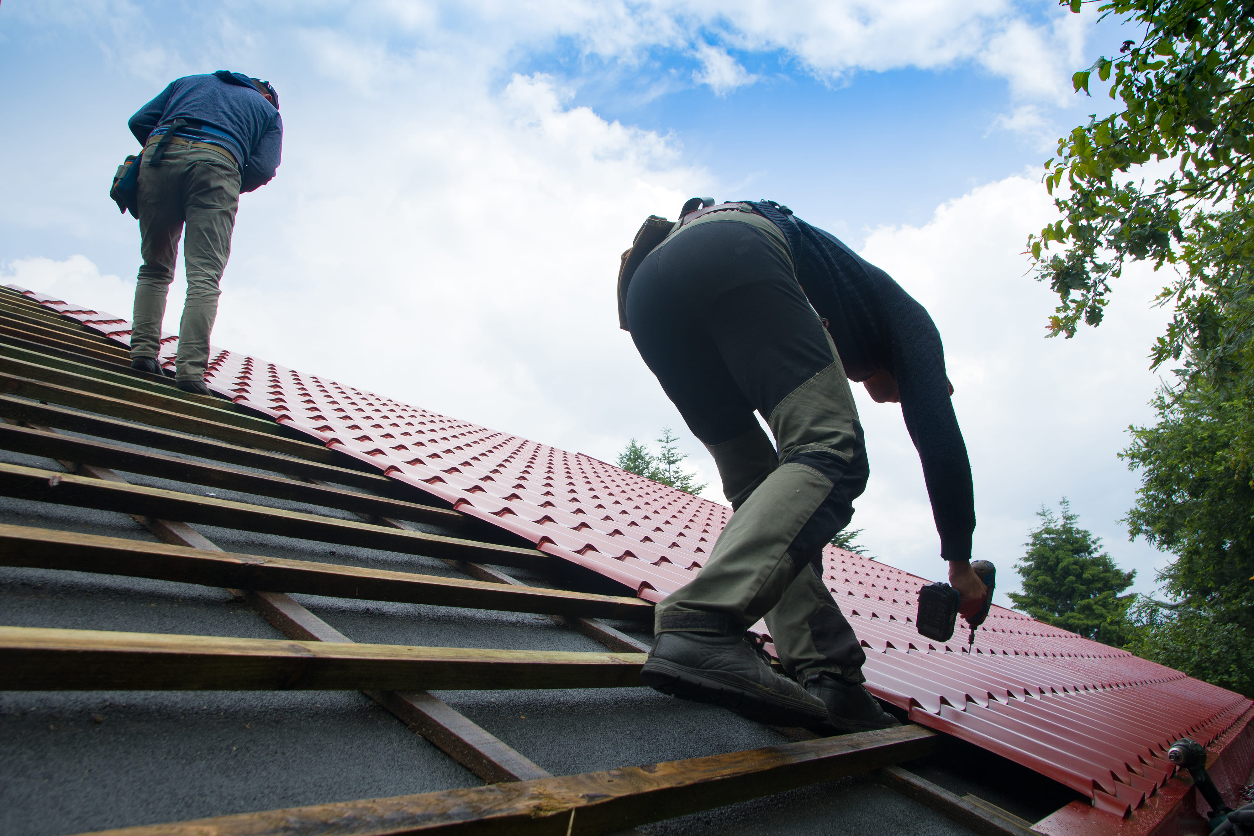 Two roofers working on a red tiled roof in Deal