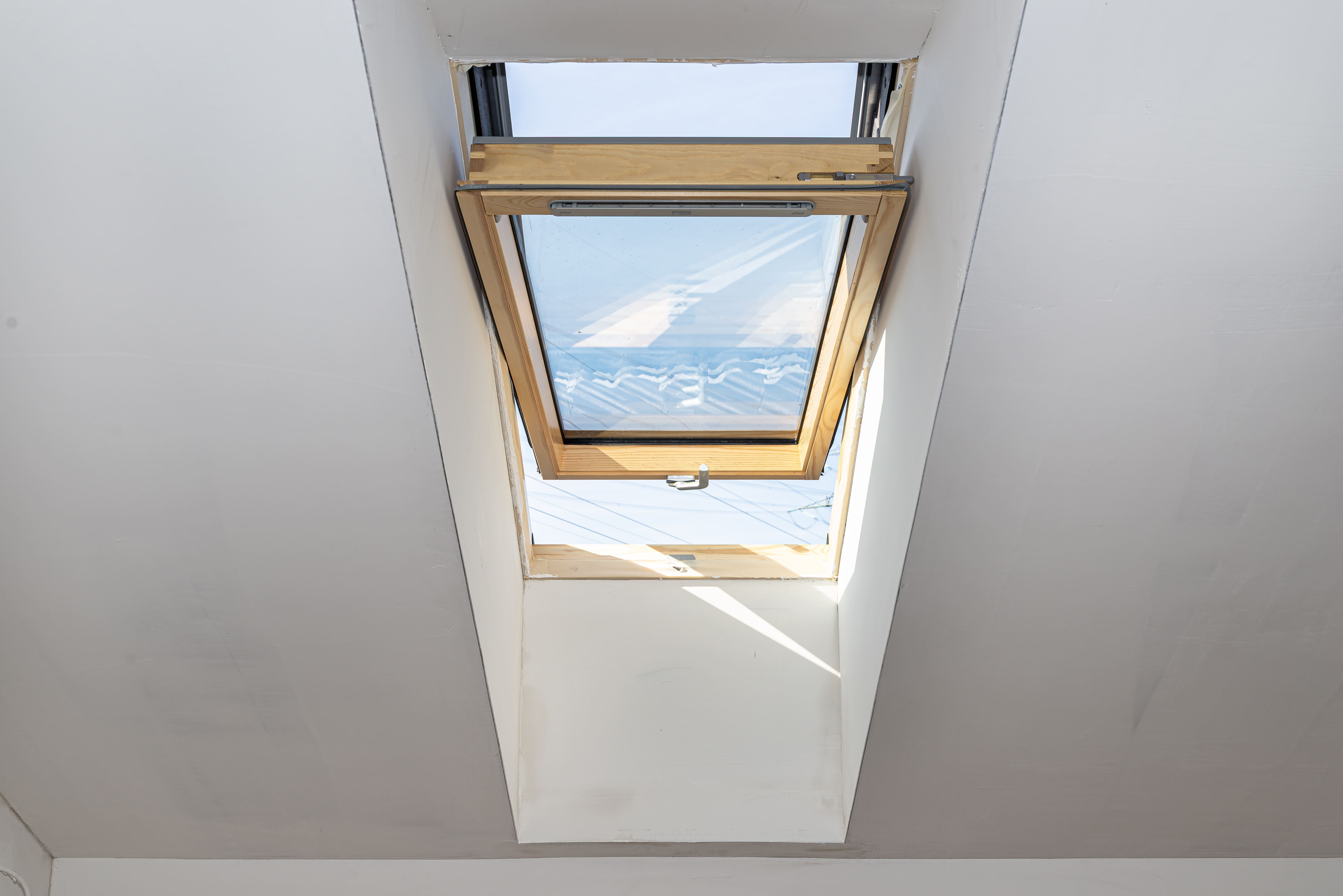 Open wooden skylight window with sea view